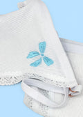 A close up image of Berry Sorbet’s Sugar Bow thong over a light blue background that accentuates the light blue bow embroidery on the front of the white ribbed cotton thong.
