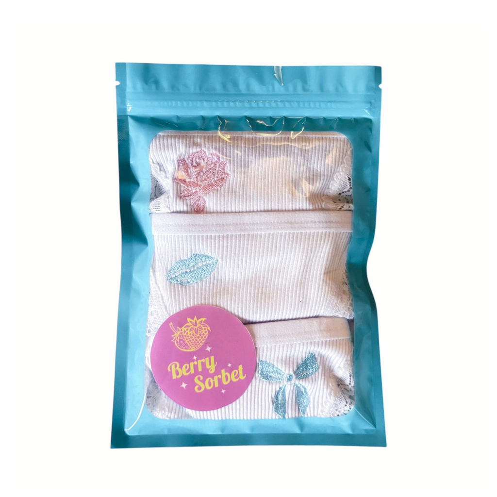 Displays our 3 pack Pastel Sugar Multipack folded in a blue and clear packaging pouch. The set contains our Low Brief in Lips in Sugar, the High Thong in Rose in Sugar and the High Thong in Bow in Sugar.